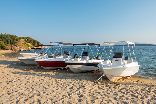 Boats for renting standing side by side on sand in Halkidiki, Greece