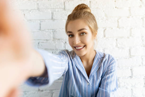 Charming girl with sweet makeup taking selfie