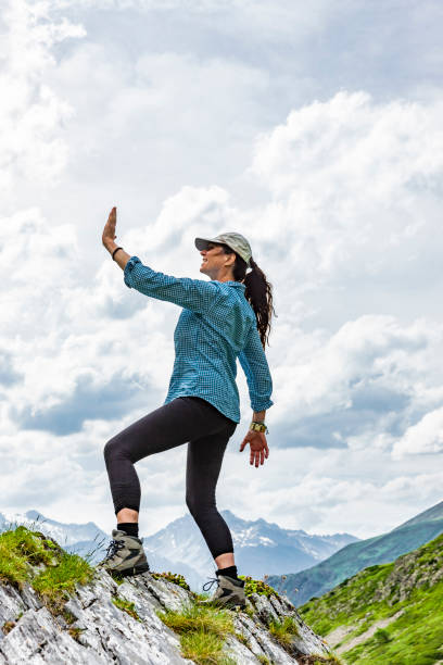 istock Female silhouette in winning pose on a mountain top 1177619678