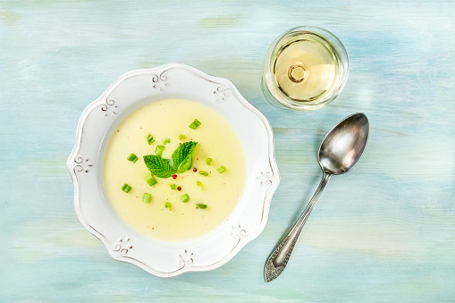 Vichyssoise, French cold soup, shot from the top with a glass of white wine