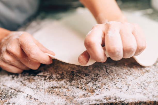 estirar la masa de pizza - makes the dough fotografías e imágenes de stock