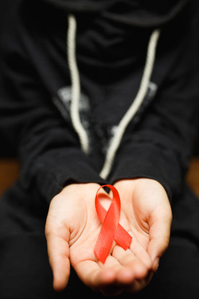 istock child with AID red ribbon on a dark background 1177626834