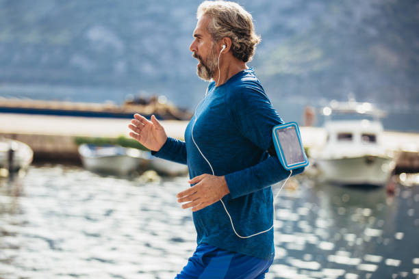 istock Active senior man jogging on the pier on a sunny day 1177627955
