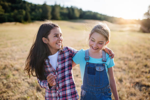 istock Two school children walking on field trip in nature, laughing. 1177628205