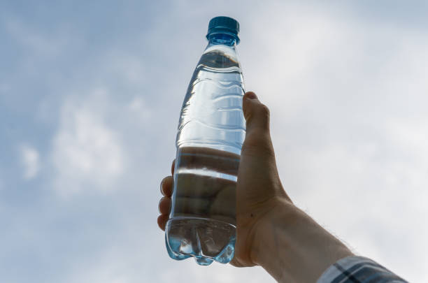 istock hand holding a plastic bottle with pure water against the sky 1177629725