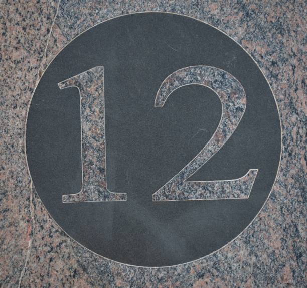 istock Number twelve black circle on pink marble. 1177629799