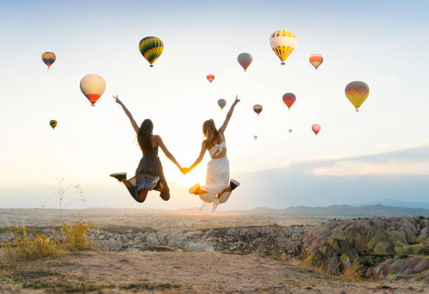 dziewczyny podróżujące i cieszące się widokiem na dolinę o zachodzie słońca w kapadocji - hot air balloon landscape sunrise mountain zdjęcia i obrazy z banku zdjęć