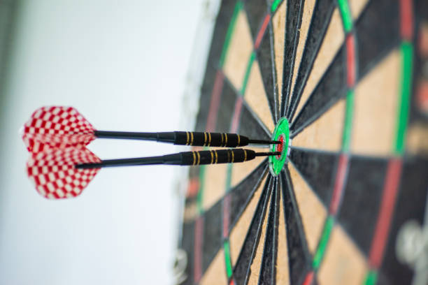 succès atteignant le fond de concept de réalisation d'objectif d'objectif de cible - trois fléchettes dans le plan rapproché d'oeil de taureau - target dartboard bulls eye dart photos et images de collection