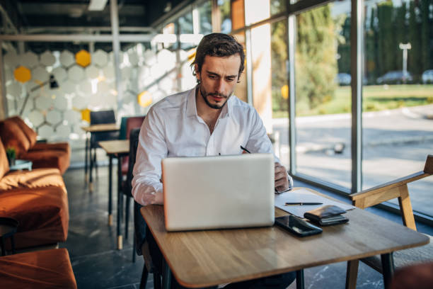istock Handsome businessman using laptop in cafe 1177634927