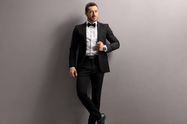 istock Elegant young man in a black suit and bow tie 1177644144