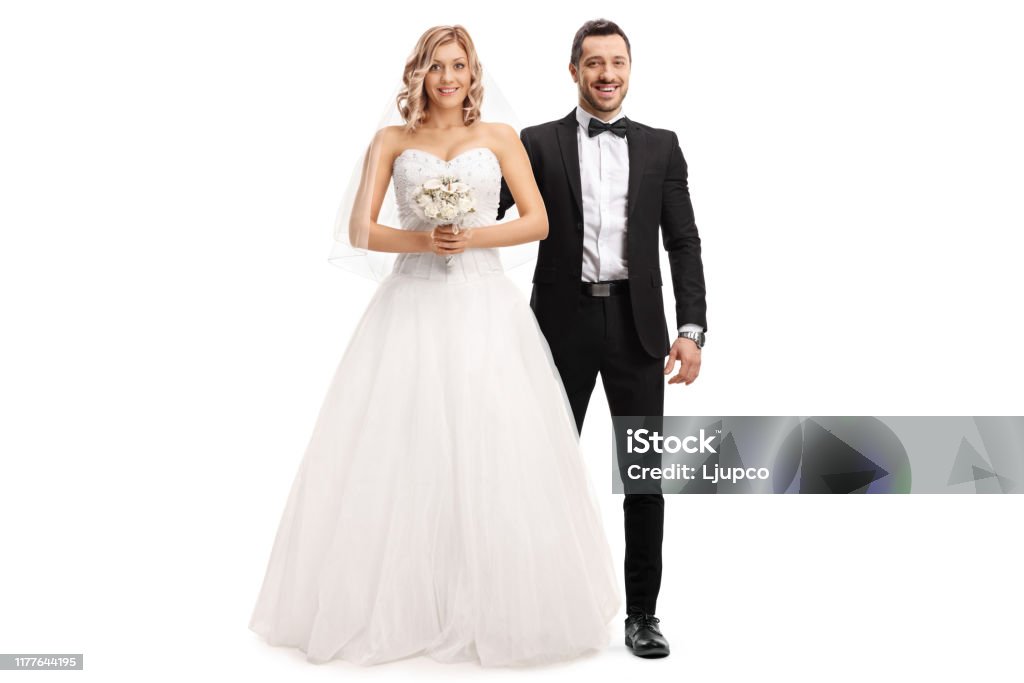 Beautiful bride and a groom by her side Full length portrait of a beautiful bride and a groom by her side isolated on white background Wedding Stock Photo