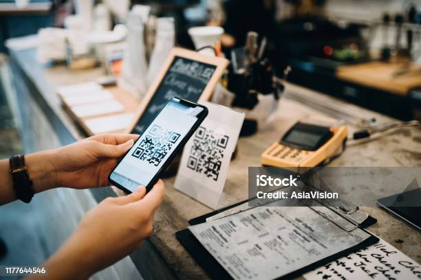 Customer Scanning Qr Code Making A Quick And Easy Contactless Payment With Her Smartphone In A Cafe Stock Photo - Download Image Now