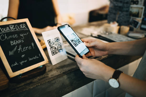 istock Customer scanning QR code, making a quick and easy contactless payment with her smartphone in a cafe 1177644574