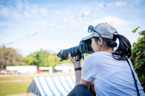 Women taking pictures at athletic meet Women taking pictures at athletic meet telephoto lens stock pictures, royalty-free photos & images