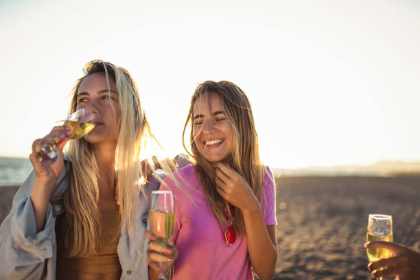 istock Friends having fun with champagne at celebration on beach 1177645592