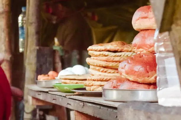 Ready-to-eat Loaf of bread, boiled egg and Roti and other food and drink items display for sell in a Street food stall in a roadside local market place. Darjeeling, West Bengal, north east India.