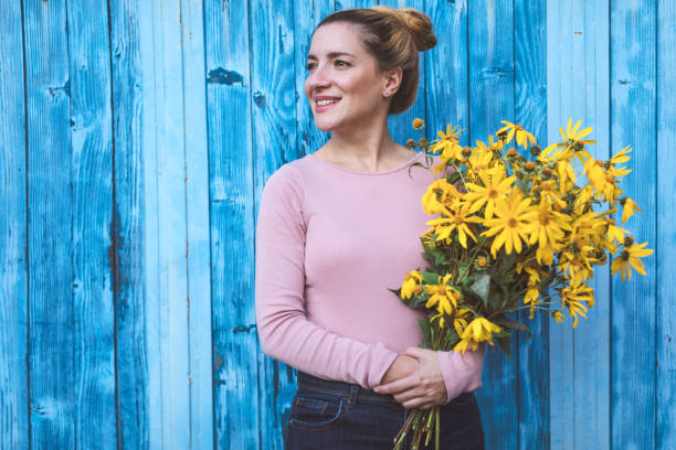 istock Beautiful woman with yellow flowers 1177647725
