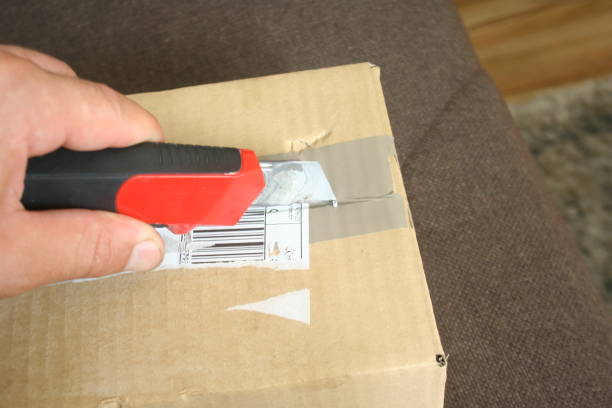 istock Opening the courier package with a red knife, which just arrived at the recipient as a gift. 1177649422