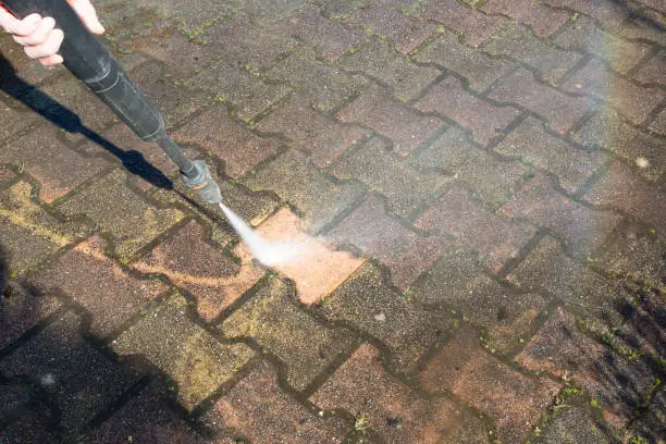 Cleaning concrete block floor driveway by high pressure water jet