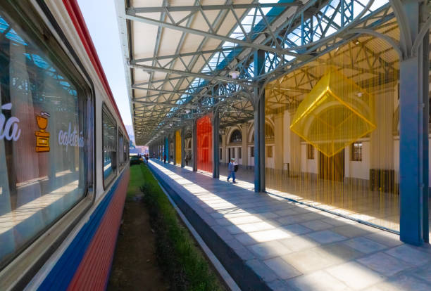Empty train station platform with white columns and clear sky