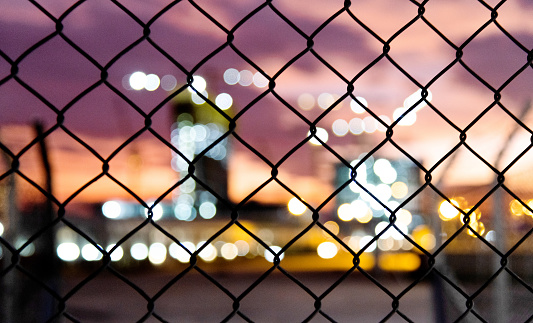 Wire fence in the city at dusk.