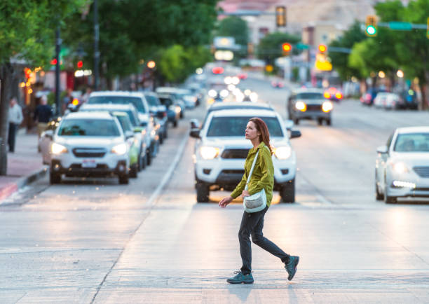 Crossing in Moab A woman walking on a crossing in Moab, Utah at dusk. small town america photos stock pictures, royalty-free photos & images