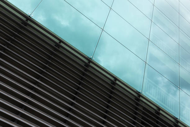 istock Diagonal view of modern wall surface, glass and metal texture with sky reflection. 1177654957