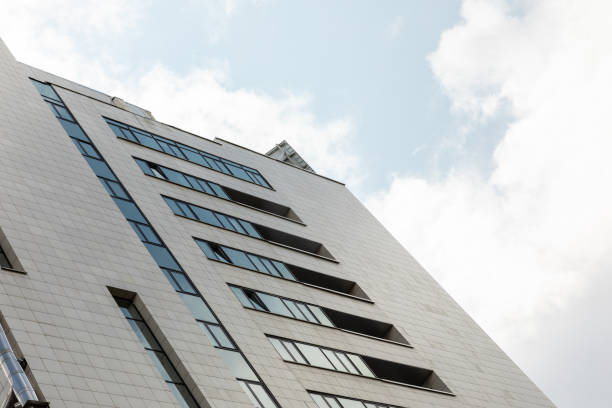 istock Ground view of tall building with windows and white facade. 1177654984