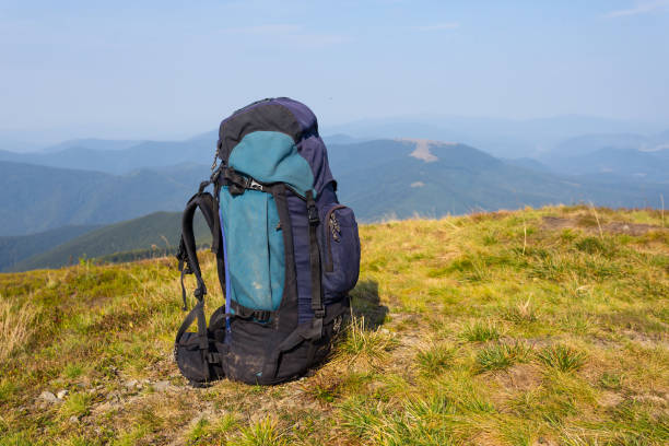 istock touristic backpack stay on a green mount slope, outdoor hiking scene 1177655052