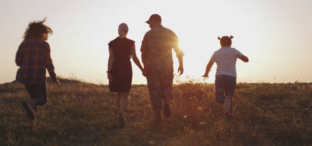 soldat och hans familj går på en äng - happy slowmotion bildbanksfoton och bilder