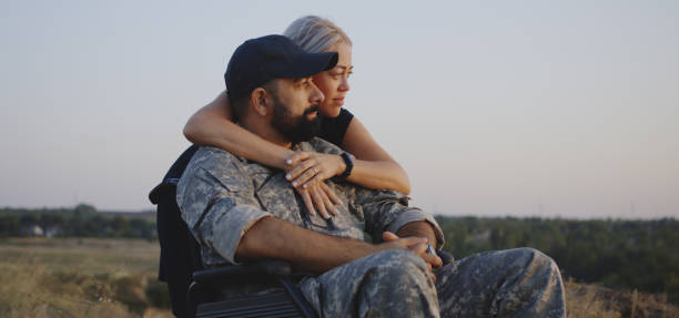 Wife hugging wheelchaired husband