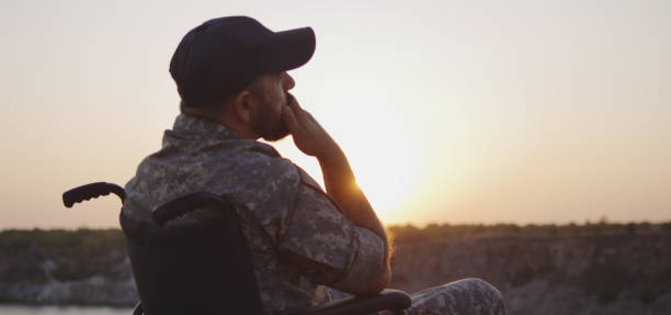 istock Soldier sitting in a wheelchair on a meadow 1177656554