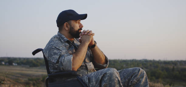 wheelchaired soldier looking away into distance - wide screen imagens e fotografias de stock