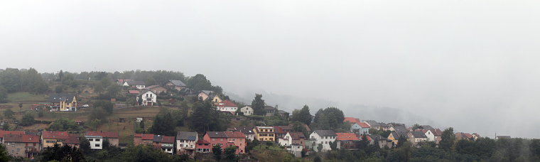 Panoramic photo of a small village in the Vosges in France in the fog
