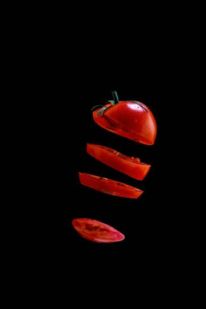istock 5 Flying tomato slices on a black background 1177665786