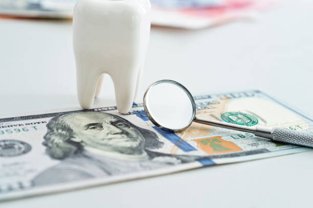 Dentist medical tools and US paper currency.