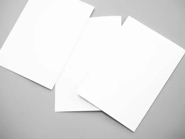 Poster mock-ups paper, white paper isolated on gray background, Blank portrait  paper A4. brochure magazine isolated on gray, can use banners products business texture background for your.