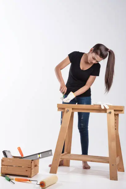 A asian woman hold  DIY tool repair wooden table on white background.image construction woman.