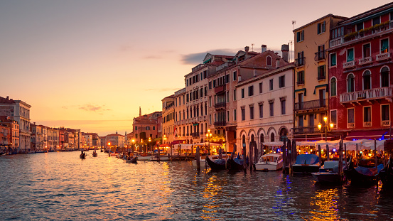Venice in summer dusk, Italy. Panorama of famous Grand Canal, famous street of Venice. Beautiful cityscape of Venice with old houses at sunset. Landscape of Venice city in evening light.