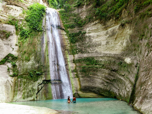 travel couple isolated at the pool of Dao Falls in Cebu Island in Philippines lovely travel couple alone at Tropical Waterfall in the jungle in Dao Falls in Cebu Island, Philippines siquijor island stock pictures, royalty-free photos & images