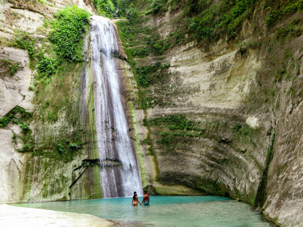travel couple isolated at the pool of Dao Falls in Cebu Island in Philippines lovely travel couple alone at Tropical Waterfall in the jungle in Dao Falls in Cebu Island, Philippines siquijor island stock pictures, royalty-free photos & images