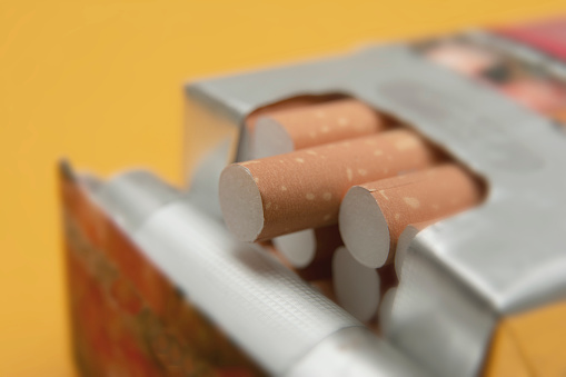 Pack of cigarettes on yellow background. Close up.