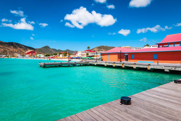 Philipsburg, Sint Maarten. Wooden dock and colorful buildings at Great Bay beach. Colorful image of Philipsburg, St Maarten Sint Maarten, Saint Martin, Caribbean. Tender platform in the city centre of Philipsburg. Popular cruise destination. Blue sky and white clouds on a beautiful summer day. saint martin caribbean stock pictures, royalty-free photos & images