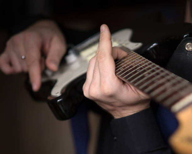 istock Human hands playing on electric guitar, close up, selected focus 1177701424