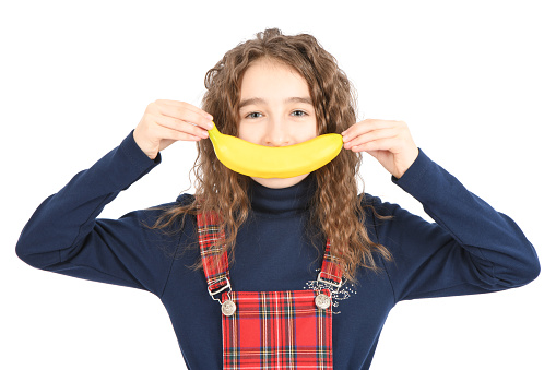 Happy girl with long curly hair making banana smile  isolated on white background. High resolution photo. Full depth of field.