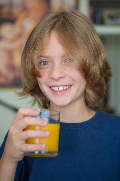 istock Young boy aged 9 holding a glass orange juice 1177705553