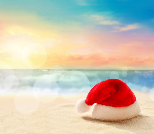 istock Christmas holidays concept. Santa claus hat on summer sand beach 1177705681