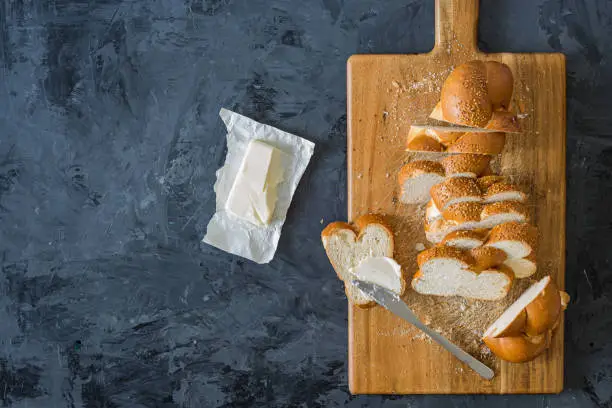 Photo of Jewish challah bread, sliced on black background