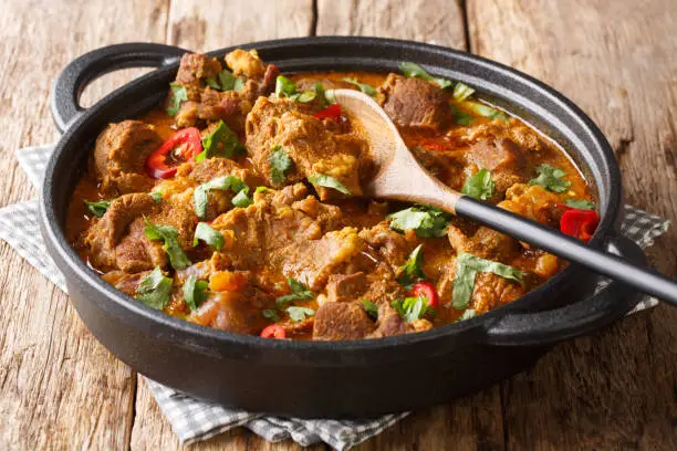 Asian cuisine traditional Lamb rogan josh with spices and gravy close-up in a pan on the table. horizontal