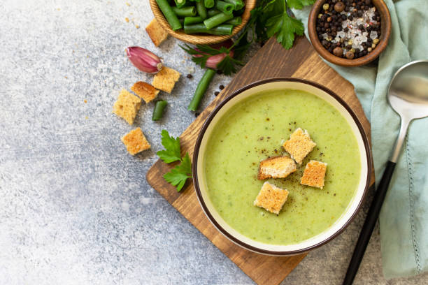 danie wegetariańskie. dietetyczna pyszna zupa kremowa z zielonej fasoli na lekkim tle. widok z góry płaski leżał. wolne miejsce na tekst. - soup zucchini spinach cream zdjęcia i obrazy z banku zdjęć